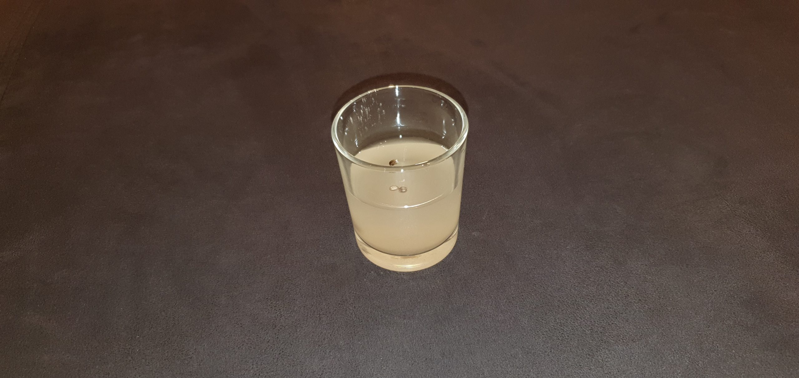 Glas mit destilliertem Wasser und Cannabis-Saatgut und Mykorrhiza darin