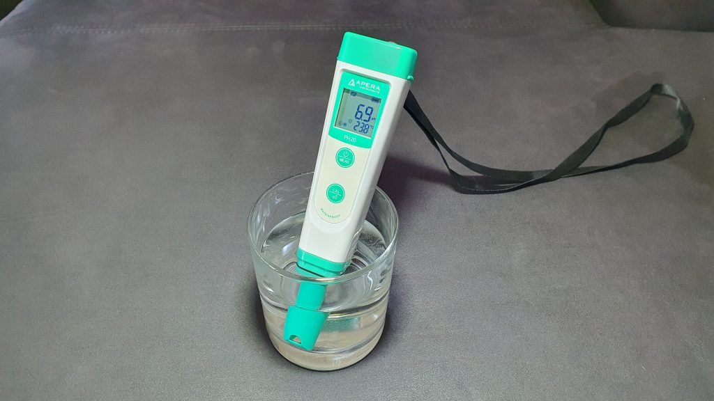 ein pH-Messgerät mit der Sonde in einem Wasserglas stehend